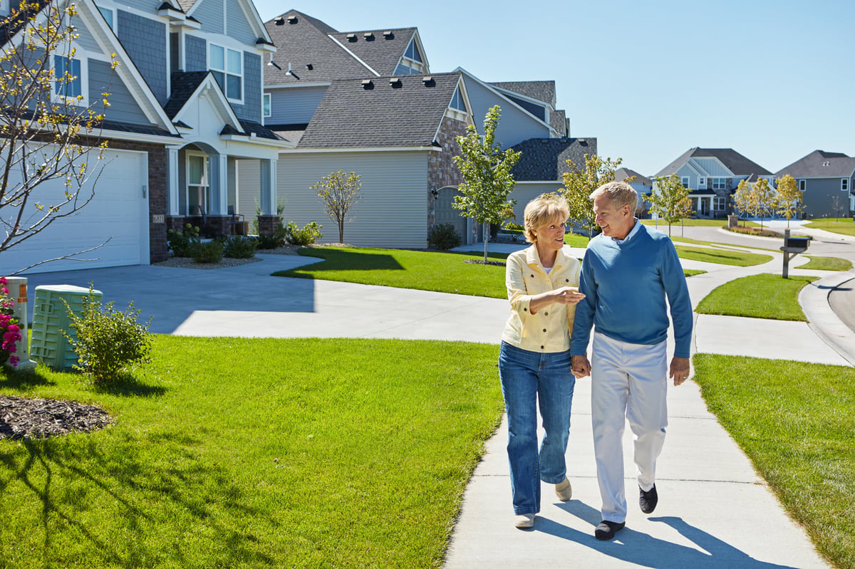 A happy couple walking together through a welcoming residential neighborhood